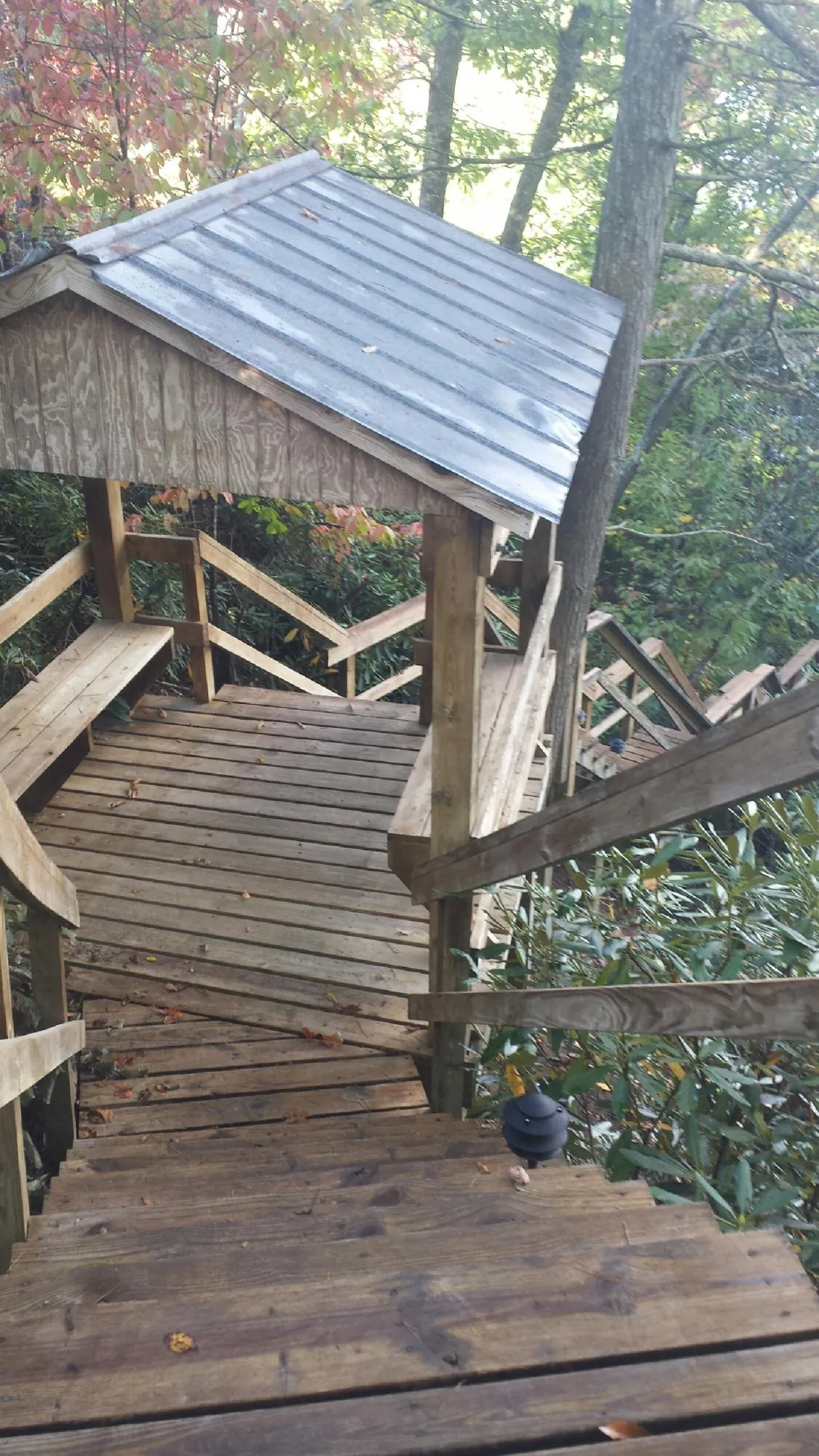 Metal roofed shelter over wooden steps on a wooded walkway — Skylight Repair & Installation work by our crew in Moriches