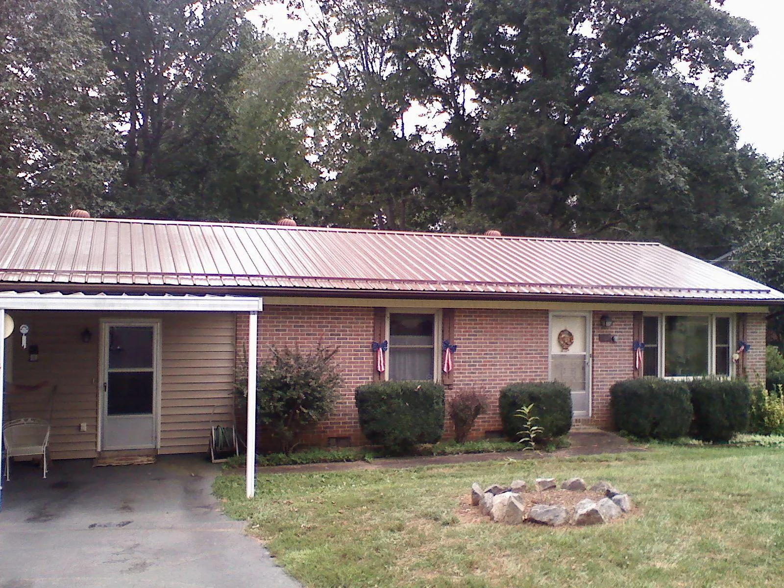 Bronze metal roof and carport on a brick ranch home — Roof Repair work by our crew in Moriches